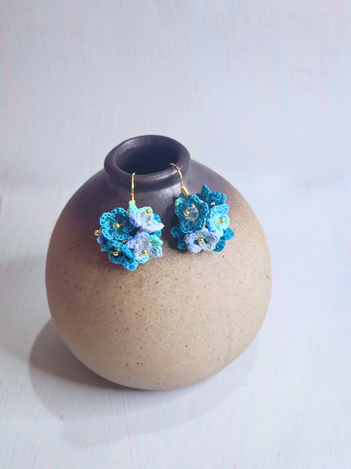 Handcrafted cluster of blue micro-crocheted star flower earrings in a lightweight and elegant design. Accented with Miyuki glass beads from Japan.