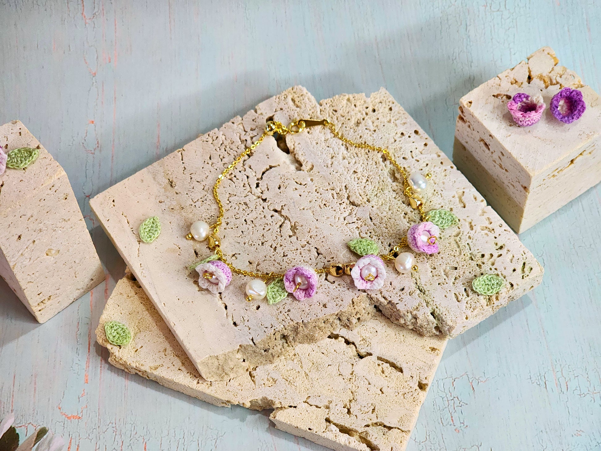 Pink-white micro‑crochet Lilies of the Valley adorned with 4.5-5mm natural Freshwater Pearls, 5-6mm natural Baroque Pearls and 18K gold-plated spacers. Gracefully set on a 18K gold-plated Y bracelet.