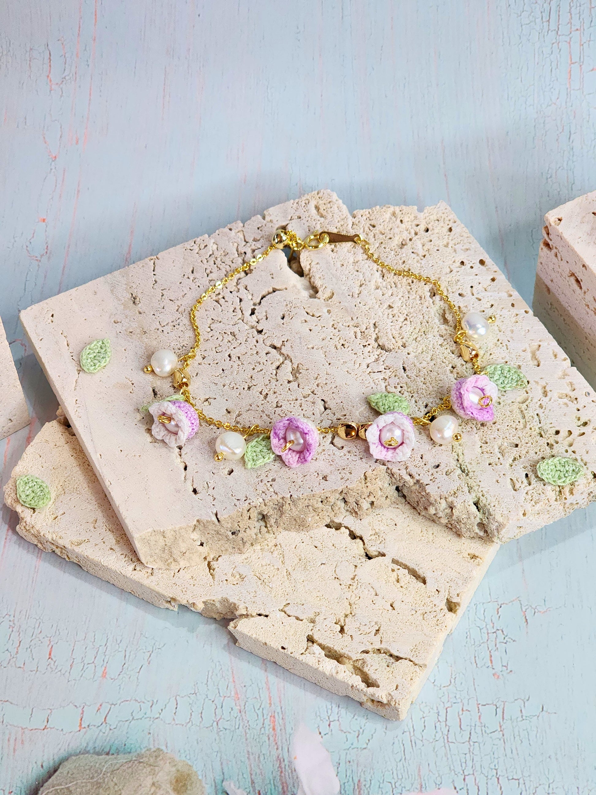 Pink-white micro‑crochet Lilies of the Valley adorned with 4.5-5mm natural Freshwater Pearls, 5-6mm natural Baroque Pearls and 18K gold-plated spacers. Gracefully set on a 18K gold-plated Y bracelet.