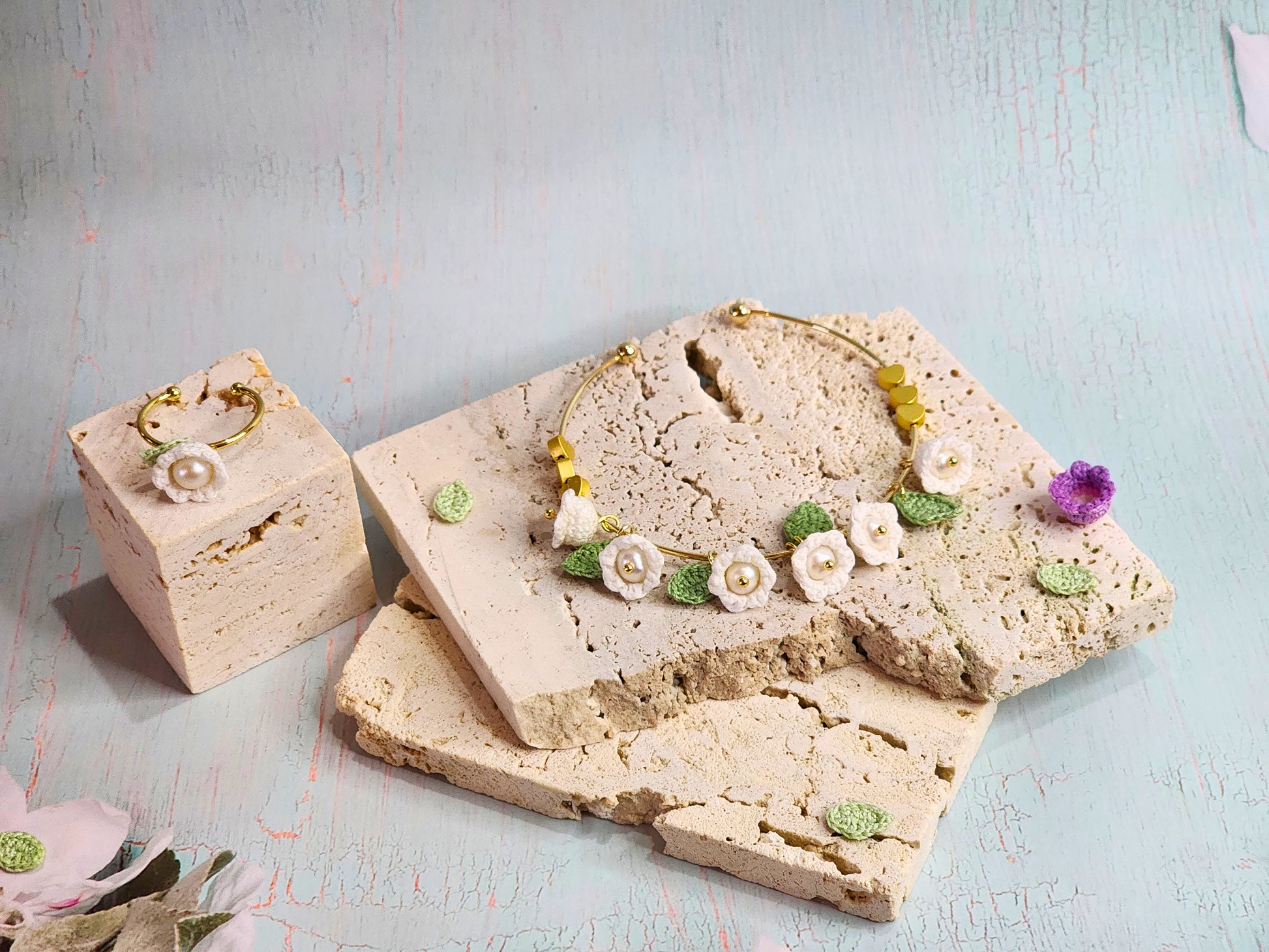 Handcrafted white micro-crochet Lily of the Valley with pearls collection featuring bracelet, ring and earrings. 18K gold-plated.