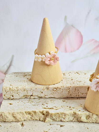 Band of natural freshwater pearls ring adorned with a delicately handcrafted micro‑crochet Sakura. 18K gold-plated adjustable ring.