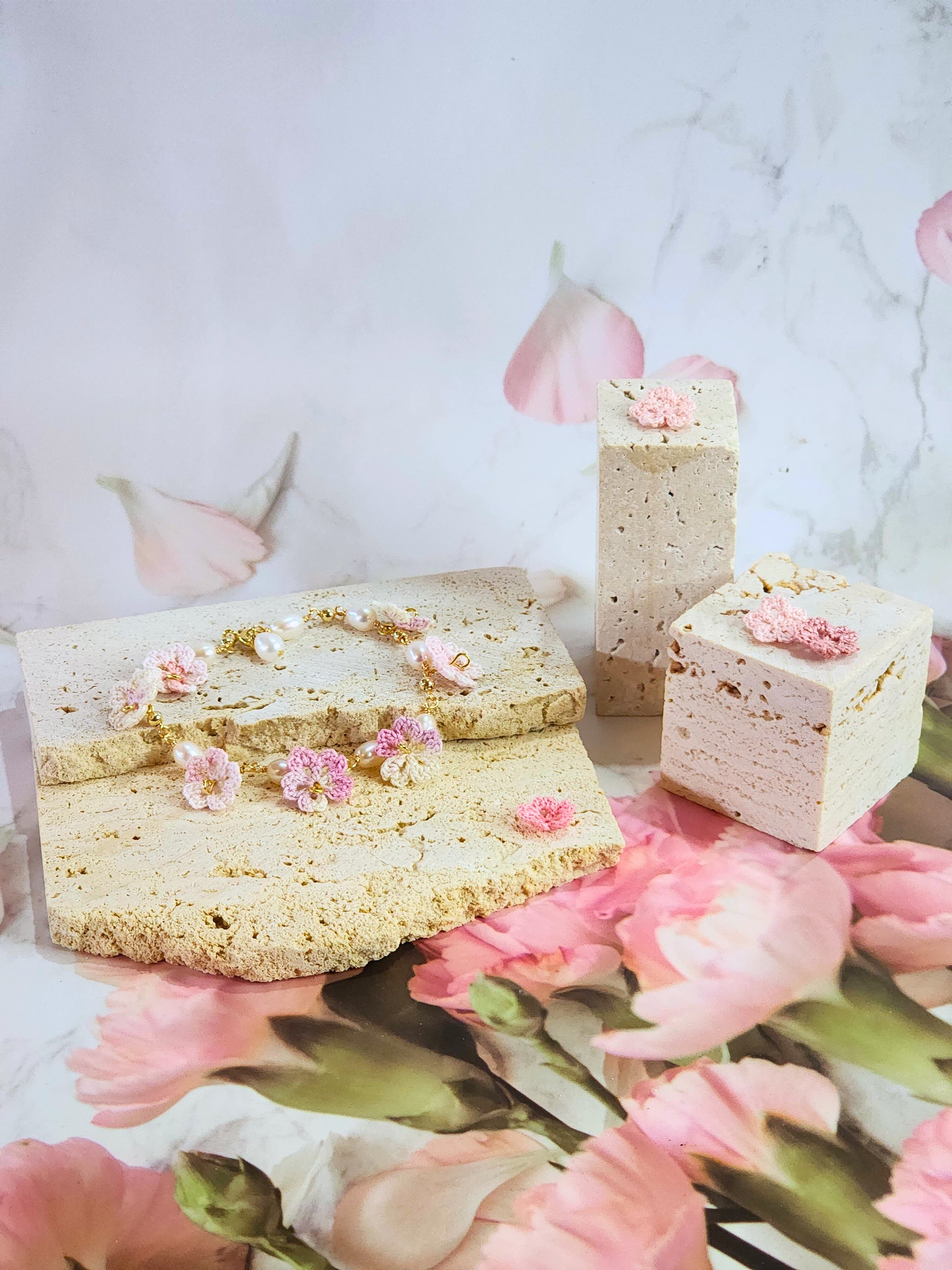 Handcrafted pink-white micro‑crochet Sakura blossoms, flanked by 5-6mm natural Baroque pearls. 14K gold-plated bracelet.