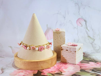 Handcrafted micro-crochet Sakura blossoms flanked by natural 5-6mm freshwater pearls on an 14K gold-plated bracelet. 